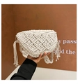 Detailed macro view of woven cotton rope texture and stylish side tassels on the beige bag - White