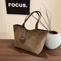 Braune Wildleder-Tragetasche mit dunklen Ledergriffen auf minimalistischer Holzfläche - Tote Bag Und Beutel / Olivgrün