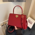 Elegant red leather handbag with golden twist lock and adjustable crossbody strap - Burgundy