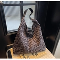 Dettaglio della borsa tote leopardata su superficie in pietra con tracolla in pelle - Leopardo Caffè