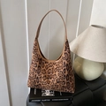 Retro leopard print hobo bag with brown strap placed on design books in home setting - Brown
