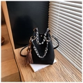 Détail du sac seau noir avec poignées tissées en pied-de-poule et breloque gland - Noir avec pendentif