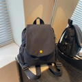 Minimalist black canvas backpack for women featuring a contrast yellow button closure - Black