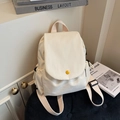 Minimalist cream canvas backpack with a bright yellow button detail in a cozy setting - Off White