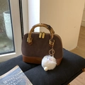 Détail d'un sac à main élégant avec anses en bambou et charm blanc en peluche douce - Café avec Pendentif