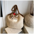 Dettaglio ravvicinato di una borsa tote in peluche bianca con ciondolo a forma di orsetto - Beige Con Ciondolo