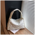 Macro detail of white quilted shoulder bag with glossy diamond texture and zipper - White