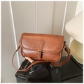 Detail shot of a brown vintage leather shoulder bag with a metal buckle and adjustable strap - Brown