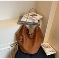 Detalle de un bolso tote grande de ante marrón con correas de cuero y colgante de corazón - Marrón