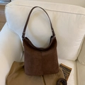 Dettaglio macro della borsa tote in pelle scamosciata marrone con cuciture e fibbie - Marrone