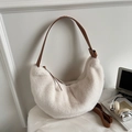 Close-up of white plush crescent bag with brown leather strap in a minimalist setting - Off-white