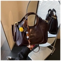 Detail of dark brown glossy leather tote bag with yellow sphere tassel and gold hardware - With Charm / Brown