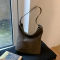 Detalle de bolso hobo de ante verde oliva con costuras verticales y hebilla de metal - Verde