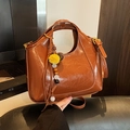 Brown semi-circular oil-wax faux leather hobo bag with a decorative tassel charm - With Charm / Brown