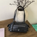 Detailansicht der schwarzen Ledertasche mit Metallreißverschlüssen und Schnallen - Schwarz