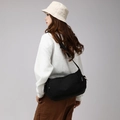 Model wearing black nylon crossbody bag in a city boy style outdoor travel setting - Black