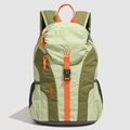 Close-up of lightweight nylon backpack showing green color-block design and orange accents - Green