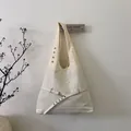 Minimalist beige shoulder tote bag with wide strap and metallic eyelet details - White