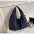 Dettaglio di una borsa tote grande in nylon blu scuro con coulisse e texture casual - Blu