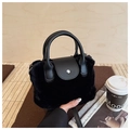 Detail of black faux fur bucket bag with leather flap, silver buckle, and top handle - Black
