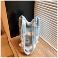 Dettaglio della borsa a secchiello in pile azzurro con motivi di pecore su legno - Pecorella blu