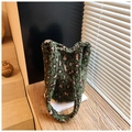 Dettaglio della borsa a secchiello in peluche leopardato verde con texture lanuginosa - Leopardo Verde