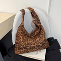 Große Canvas-Tragetasche mit Leopardenmuster und goldener Schnalle auf weißem Stuhl - Leopardenmuster
