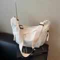 Witte canvas dumpling tas met kleurrijke vlinderborduurwerk en een brede schouderband - Off-wit