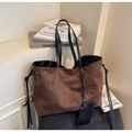 Détail du sac cabas en daim marron foncé avec lettrage embossé et bandoulière noire - café