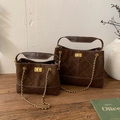 Detailed macro view of vintage brown suede tote bags with golden metal clasps and chain straps - Large / Brown