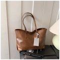 Detail view of large brown vintage tote bag with PU leather texture on design books - Brown