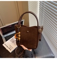 Détail du sac seau marron avec empiècements en daim et pendentif vintage en perles de bois - Avec Pendentif / café