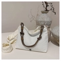 Detalle del bolso de lona blanca con asas de cuerda marrón y logotipo metálico circular - Blanco Roto