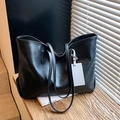 Minimalist black tote bag in large capacity with sleek leather texture and hanging tag - Black