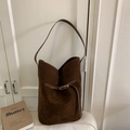 Detailed macro view of dark brown suede bucket bag with silver metal buckle closure - Brown
