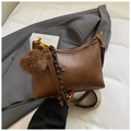 Detail of brown faux leather hobo bag with plush ball charm and woven shoulder strap - Brown with Pendant