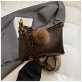 Detail of dark brown dumpling bag with plush charm and ethnic patterned strap - Coffee with Pendant