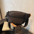 Black quilted canvas waist bag with orange logo label and adjustable wide strap - Black