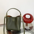 Macro detail of dark green pebbled leather texture and embossed logo on the bucket bag - Dark Green