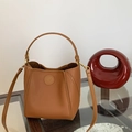 Detail of brown lychee grain leather bucket bag with gold hardware and logo embossing - Yellow Brown