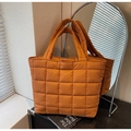 Gros plan sur un sac cabas matelassé caramel en nylon métallisé avec coutures carrées - Marron
