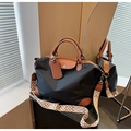 Detalle del bolso de nailon negro con ribete de cuero y correa ancha con diseño geométrico - Negro