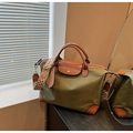 Detalle del bolso de nailon oliva con asas de cuero marrón y correa ancha geométrica - Verde