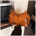Detail van een bruine glanzende hobo-tas met zijzakken en decoratieve trekkoord details - Bruin