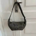 Dunkelgraue Hobo-Tasche aus Leder mit weißen Ziernähten und verstellbarem Riemen - Schwarz