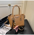 Detailaufnahme braune Eimertasche aus Leder mit Perlenanhänger und Metall-Namensschild - Khaki