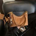 Minimalistische tiefbraune Wildleder-Schultertasche mit goldenen Beschlägen und Quasten - Braun mit Anhänger