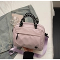 Dettaglio borsa in nylon lilla con manico in corda intrecciata e logo in metallo - Rosa Grande