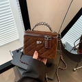Quilted dark brown velvet crossbody chain bag with silver hardware in a minimalist setting - Brown