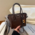 Dunkelbraune Leder-Eimertasche mit Holzperlenanhänger und verstellbarem Gurt - Braun